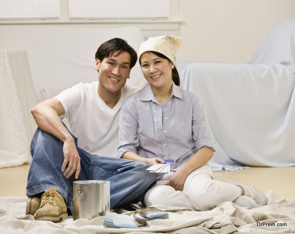 Couple sitting with paint can and paint swatch preparing to deco