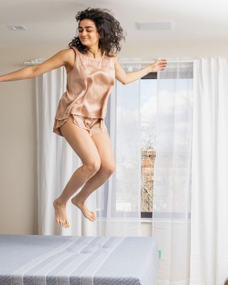 woman jumping on mattress