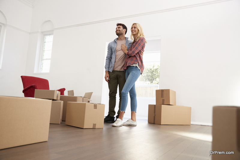 Couple Carrying Boxes Into New Home